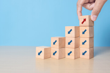 wooden block cubes with rising business graph among decline graph