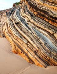 Stratified rock face on sandy beach