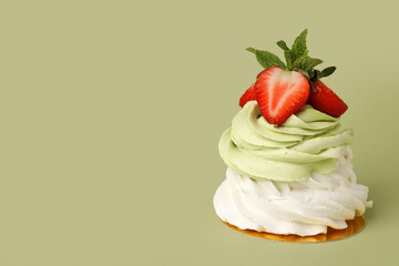 Sweet Pavlova cake with fresh strawberries and mint on green background