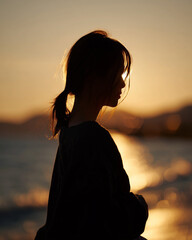 夕陽に照らされた若いアジア人女性のシルエット