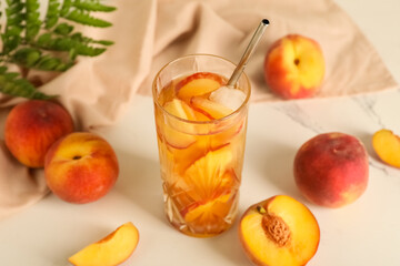 Napkin and glass of tasty peach iced tea on marble background, closeup