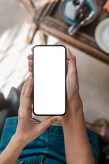 Hands holding a smartphone with a blank screen, ideal for app mockups or design presentations.