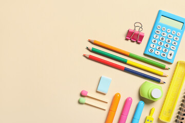 Different school stationery supplies on beige background