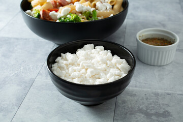 A view of a pile of dairy-free feta cheese crumbles, in a bowl.