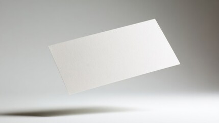 A single white rectangular paper floats horizontally against a light grey gradient background,