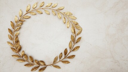 A golden laurel wreath rests on an off white marbled surface,