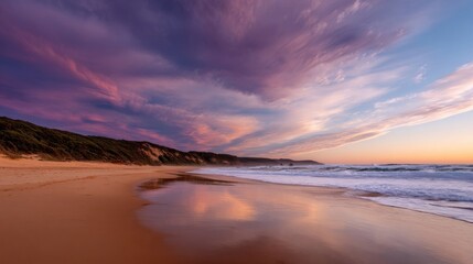 Serene beach sunset with pink, purple, and orange sky reflecting on wet sand, gentle waves, distant hills,