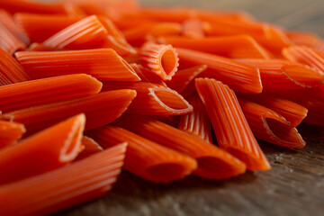 A closeup view of a pile of gluten-free red lentil penne pasta.
