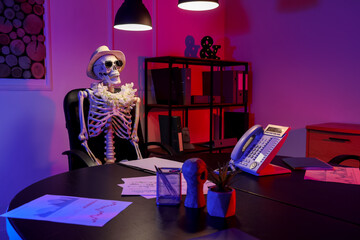 Human skeleton model with summer accessories in office at night