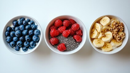 Three bowls blueberries, raspberries, bananas, and walnuts
