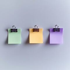 Three pastel sticky notes clipped on grey surface, centered