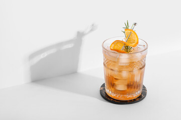 Glass of tasty Old Fashioned cocktail with rosemary on grey background