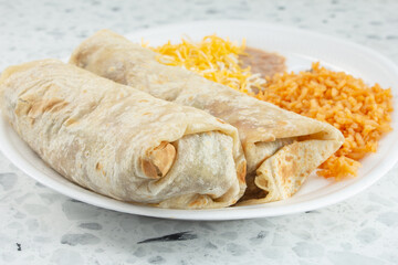 A closeup view of a two burritos plate.