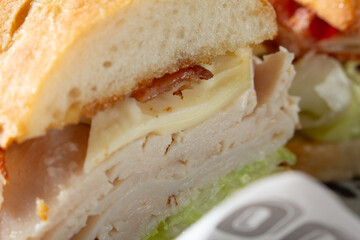A closeup view of a turkey bacon sandwich.