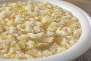 A closeup view of a bowl of crab fish maw soup.