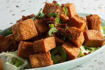 A closeup view of a plate of salt and pepper tofu.