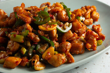 A closeup view of a plate of stir fried diced chicken.