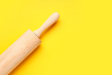 Rolling pin on yellow background