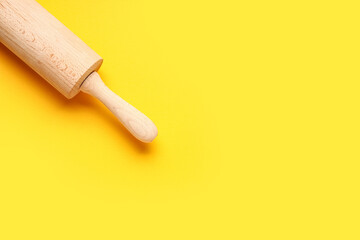 Rolling pin on yellow background