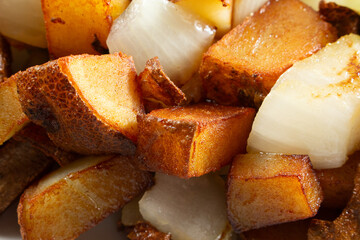 A closeup view of a pile of breakfast potatoes, as a background.