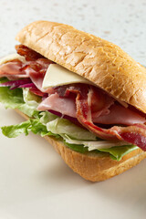 A closeup view of a ham bacon cheese sandwich.