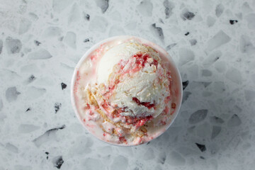 A top down view of a scoop of strawberry cheesecake ice cream.