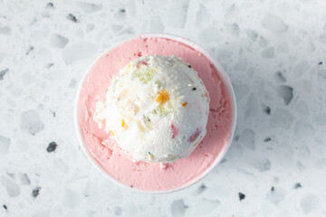 A top down view of a strawberry and fruit chunk ice cream cup.
