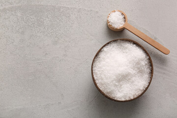 Bowl and scoop with sea salt on grunge background