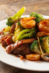 A view of a plate of stir-fried scallop, shrimp and beef.