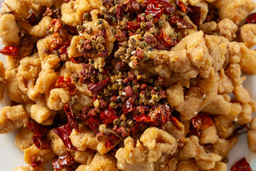 A top down view of a plate of spicy popcorn chicken.