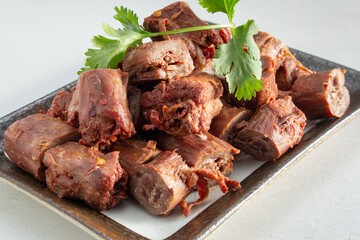 A view of a plate of chopped spicy duck neck.