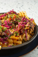 A closeup view of a plate of loaded waffle fries.