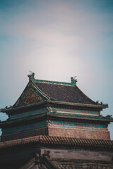 Fototapeta premium A grayscale snapshot reveals a weathered, old Beijing building with symmetrical architectural details lining a narrow, paved street, hinting at a historic urban scene.