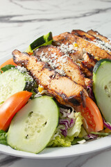 A closeup view of a grilled chicken salad.