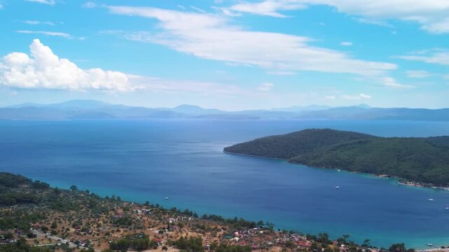 aerial footage showcasing the natural beauty of Gokova Bay Gokova Korfezi in Turkey. This serene Mediterranean landscape features crystal clear turquoise waters, lush green hills, and charming coastal