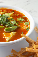 A view of a bowl of chicken tortilla soup.
