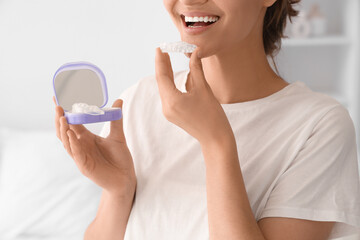 Woman with box and occlusal splint in bedroom, closeup