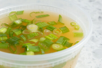 A closeup view of a container of miso soup.