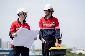 Two engineer checking solar energy system looking blueprint together for planning installation solar panel, renewable energy and sustainable technology, clean electricity, industry and solar cell.