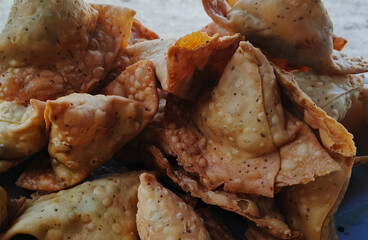 Delicious crispy golden brown samosas piled together freshly fried and ready to serve. traditional Asian street food snack made with this pastry filled and deep fried until cruchy, south Asian street 