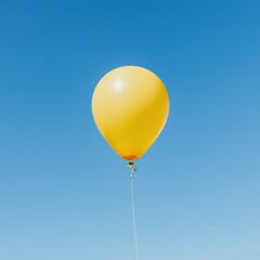 Obraz premium Bright yellow balloon floats against a clear blue sky — simple, joyful symbol of celebration, freedom, or childhood wonder with minimalist charm.