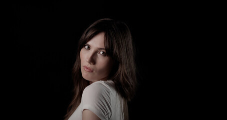 Naklejka premium Fashion model turning head and looking over shoulder with captivating expression