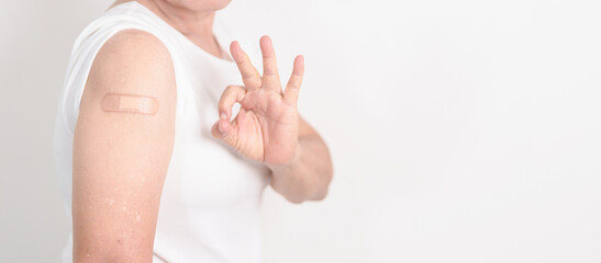 Elderly Woman with bandage after received vaccine. Vaccination and Immunization for Influenza, Herpes Zoster, Tetanus, Covid 19 booster, Dengue, Encephalitis, Rabies, Pneumococcal, IPD, RSV Vaccines