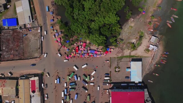 Wewak Sundaun fish Market Wewak Hill buildings cars traffic people boatsPapua New Guinea aerial drone downtown coastal town coastline beach Dogreto Bay sunny morning colorful umbrellas upwards