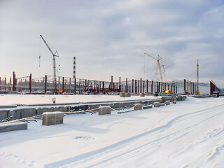 Construction site in winter with cranes and snow