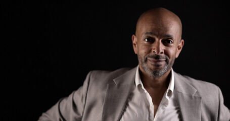 Studio portrait of a confident african american businessman smiling on a black background