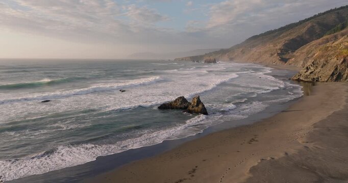 A serene California coast beach under a cloudy sky in daylight