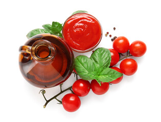 Glass bowl of tasty tomato sauce with basil leaves and jug of oil on white background