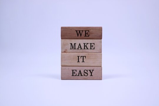Naklejki A simple arrangement of wood blocks spelling ‘WE MAKE IT EASY’, symbolizing teamwork, support, and straightforward solutions.