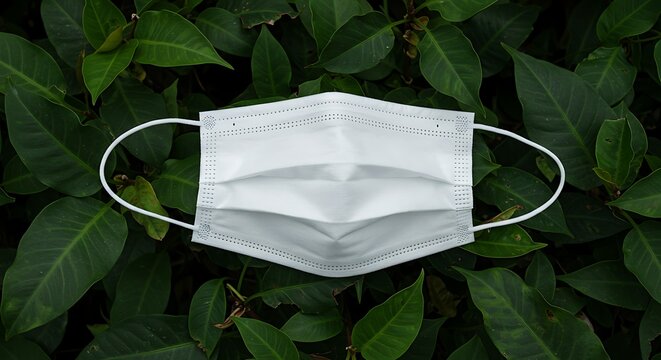White face mask on green foliage concept for health protection - Powered by Adobe